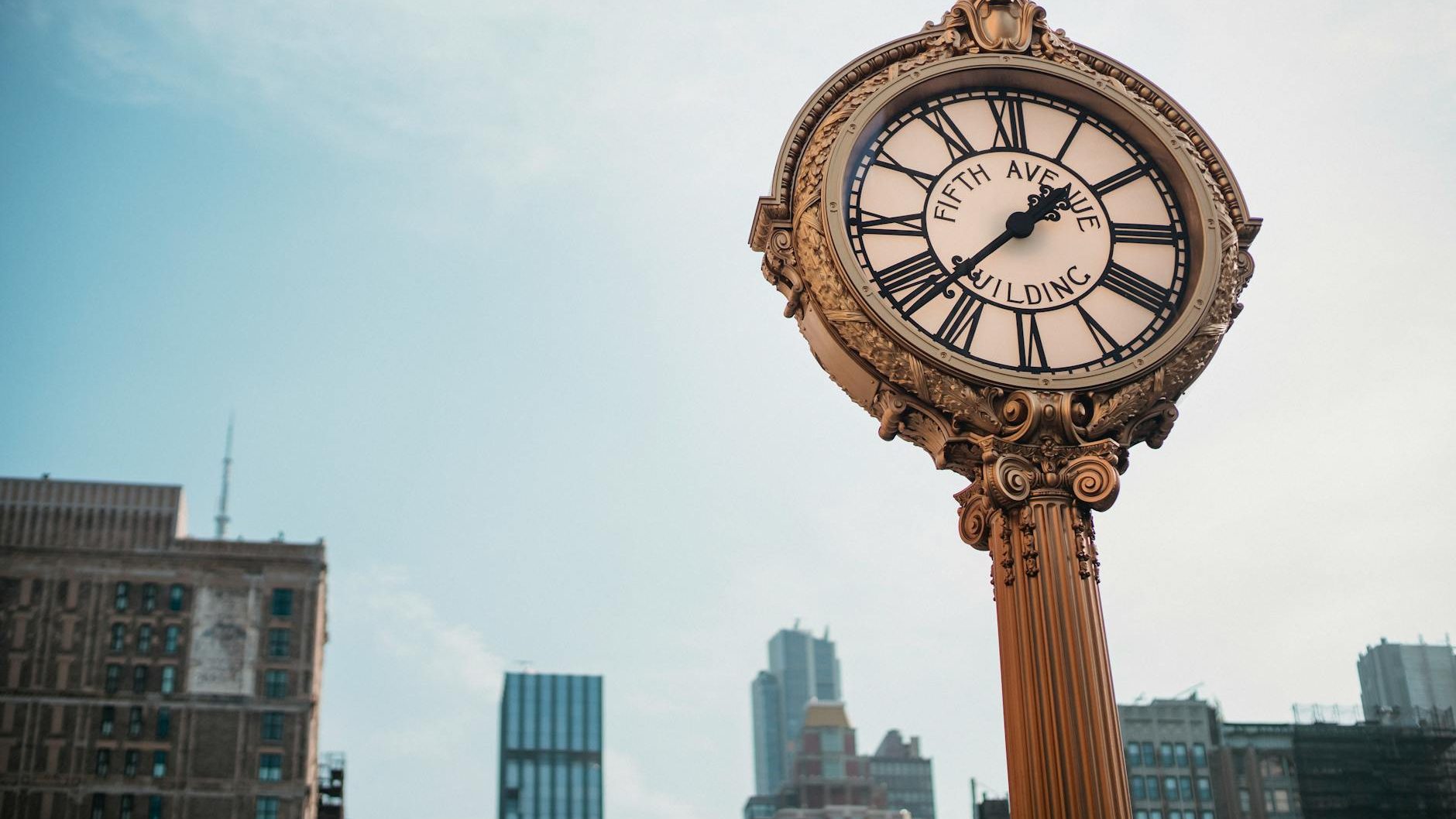A clock in front of a city skyline