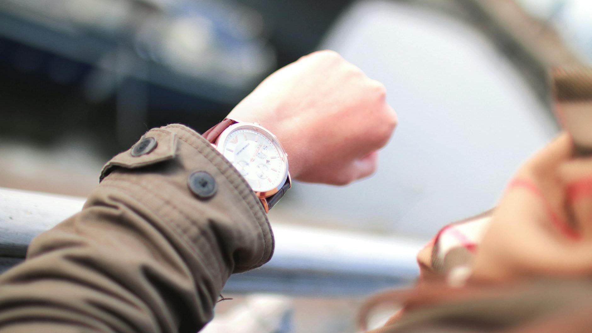 An unseen figure checks their watch